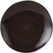A black Tuxton china plate with a white geode mushroom swirl pattern in the center.