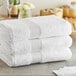 A stack of three white Lavex Luxury bath towels.