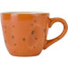 A white china coffee cup with a coral speckled design.