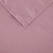 A pink square cloth table cover with a folded edge.