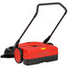 A red and black Bissell Commercial battery powered floor sweeper with a handle.