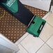 A green and black Bissell Commercial cloth bagged upright vacuum cleaner on the floor.