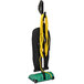 A green Bissell commercial upright vacuum cleaner with yellow cords.