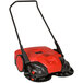 A red and black Bissell Commercial outdoor power sweeper with wheels.