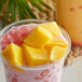 A close-up of a yellow mango pudding in a glass.