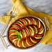 A Tablecraft stainless steel casserole dish filled with colorful vegetables on a table with a fork.