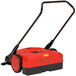A red and black Bissell Commercial outdoor power sweeper.