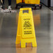 A yellow Carlisle wet floor sign with "Caution Wet Floor" in black text.