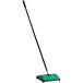 A green and black Bissell Commercial floor sweeper.