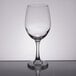 A clear Libbey tall wine glass on a reflective surface.