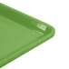 A close up of a lime green Cambro dietary tray with a plastic handle.