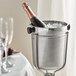 An American Metalcraft stainless steel champagne bucket with a bottle of champagne in ice.
