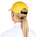 A woman wearing a yellow Headsweats 5-panel cap with a ponytail.