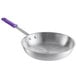A close-up of a silver aluminum frying pan with a purple silicone handle.