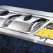 A Vollrath PanaMax dome cover on a buffet line with trays of food.