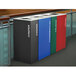 A row of rectangular plastic recycling bins in emerald, blue, and red. Each has a different white textured design.