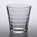 A clear Duralex glass tumbler with a patterned curved edge.