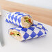 Two sandwiches wrapped in Choice blue and white check deli paper.