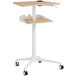 A natural wood Safco adjustable height standing laptop cart with wheels.