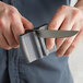 A man using a Mercer Culinary pocket knife sharpener on a knife with a gray handle.