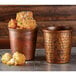 Two American Metalcraft Hammered Antique Copper Mini Cups filled with fried food on a table.