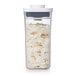 A clear rectangular OXO food storage container with a white lid filled with shredded coconut.