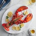 A Boston Lobster Company lobster on a plate with lemon slices and a fork.
