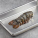 A Boston Lobster Company 10 lb. case of lobster tails on a metal tray.