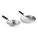 Two silver Vollrath Wear-Ever frying pans with black silicone handles.