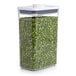 A OXO Good Grips rectangular food storage container with green peas inside and a white lid.