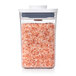 An OXO Good Grips clear square food storage container with a white lid filled with pink salt.