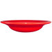 A close up of a red International Tableware stoneware bowl with a deep rim.