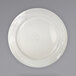 A close-up of a white International Tableware Newport stoneware plate with a curved edge.