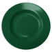 A close-up of a green stoneware pasta bowl with a circular center.