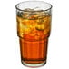 A stackable Arcoroc beverage glass filled with iced tea and ice cubes.