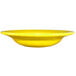 A close up of a yellow International Tableware stoneware deep rim soup bowl.