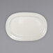 An International Tableware ivory stoneware oval platter with an embossed rim on a gray background.