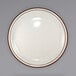 An International Tableware ivory stoneware plate with a brown speckled rim.