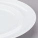 A close-up of a 10 Strawberry Street Taverno white porcelain bread and butter plate with a white rim.