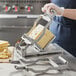 A woman using a Choice Prep cheese slicer to cut cheese on a counter.