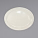 An International Tableware ivory stoneware platter with a narrow rim on a gray surface.