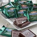An open package of Ghirardelli Dark Chocolate Mint Squares on a table.