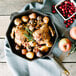 A FINEX cast iron skillet filled with chicken, potatoes, apples, and cranberries.