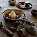A FINEX cast iron skillet with ice cream and fruit on a table.