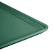 A close-up of a Cambro Sherwood Green fiberglass dietary tray on a table.