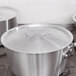 A Vollrath stainless steel cover on a pot.