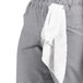 A close-up of Uncommon Chef women's black and white houndstooth chef pants with a white towel in the pocket.