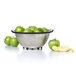 A OXO stainless steel colander full of green apples.
