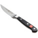 A Wusthof Classic serrated paring knife with a black handle.