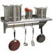 An Advance Tabco stainless steel wall shelf with pots and pans on it.